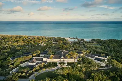 Aerial view across COMO Parrot Cay's resort buildings and pools towards the sea