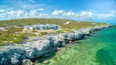 Bird's-eye view of an oceanfront Sailrock villa beside the rocky South Caicos shoreline