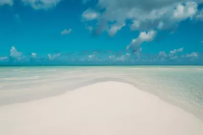 An empty sweep of white sand and shallow turquoise water at Pine Cay