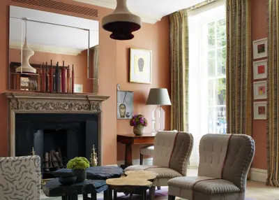 The drawing room at Dorset Square Hotel, terracotta walls and a carved fireplace hung with antique mirrors